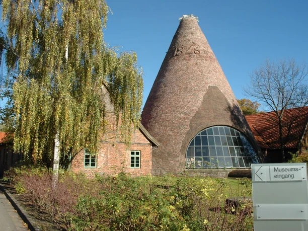 Glashütte Gernheim Historische Glashütte Gernheim mit auffälligem Kegeldach aus Backstein, umgeben von Bäumen.
