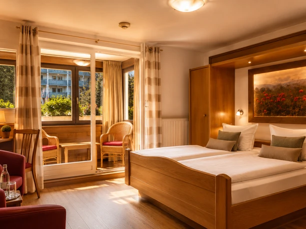 Doppelzimmer mit Balkon Hotel Sauerländer Hof Willingen Doppelzimmer im Hotel Sauerländer Hof mit Holzbett, Sitzbereich, warmem Licht und Balkon mit Blick ins Grüne.