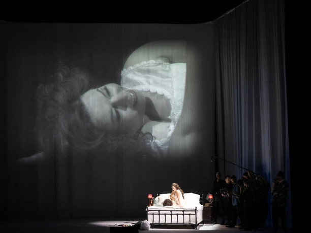 Magdalena Hinterdobler, Bianca Andrew, Paweł Brożek, Statisterie der Oper Köln, Alina König Rannenberg Opernszene aus Der Rosenkavalier: Frau im Bett, große Projektion und Ensemble im Schatten