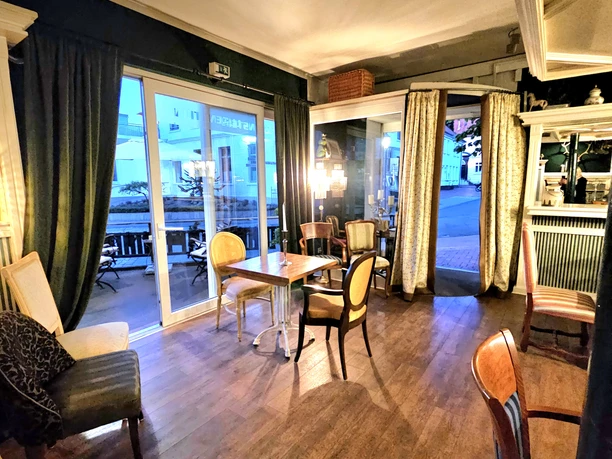 Bistro Lugenstein Gastraum im Bistro Lugenstein mit Holzboden, Stühlen, Vorhängen und Blick zur Terrasse.