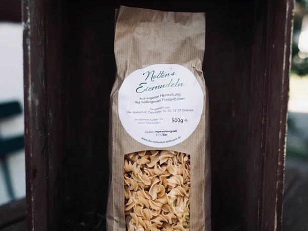 Egg Noodles from Noltenhof in Delbrück A package of egg noodles in a wooden box lined with pine branches.