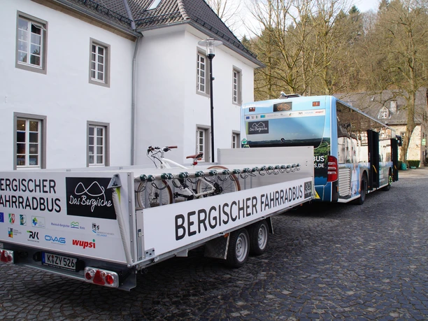 Anhänger Bergischer FahrradBus Bergischer Fahrradbus mit Anhänger, beladen mit Fahrrädern, steht auf einem Kopfsteinpflasterplatz.