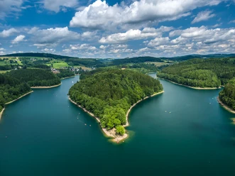 Aggertalsperre Die Aggertalsperre in Gummersbach, umgeben von Wäldern und Hügeln, unter einem bewölkten Himmel.