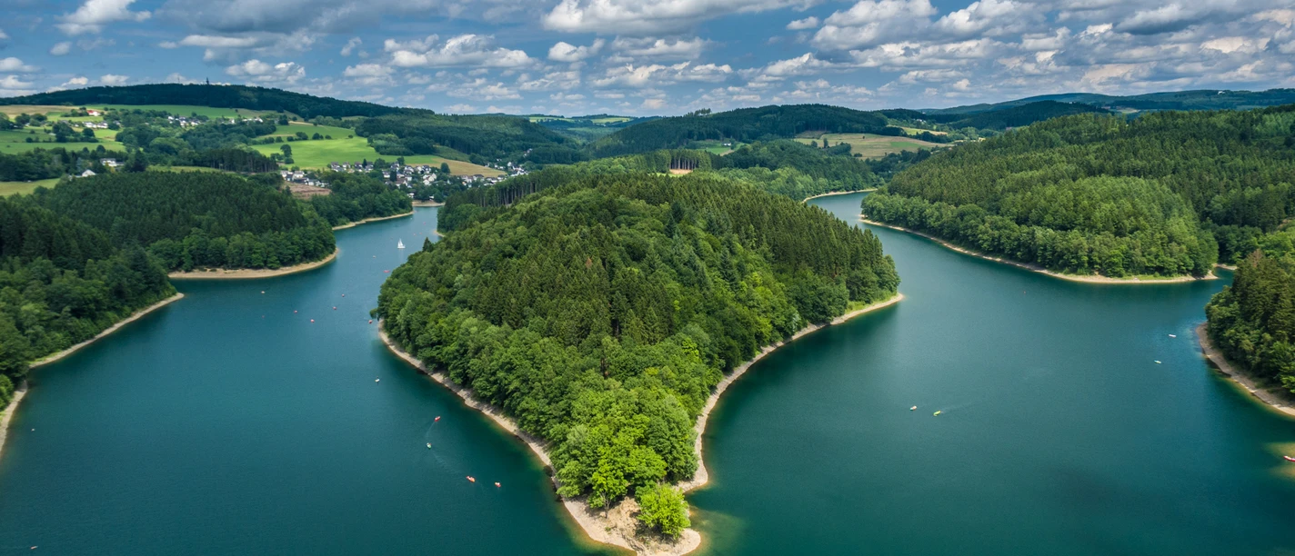 Aggertalsperre Die Aggertalsperre in Gummersbach, umgeben von Wäldern und Hügeln, unter einem bewölkten Himmel.