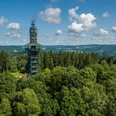 Unnenbergturm Aussichtsturm im Wald Gummersbachs, umgeben von Bäumen mit bewölktem Himmel, Panoramablick in die Ferne.