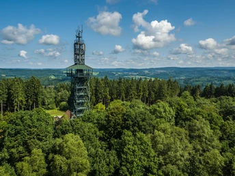 Unnenbergturm Aussichtsturm im Wald Gummersbachs, umgeben von Bäumen mit bewölktem Himmel, Panoramablick in die Ferne.