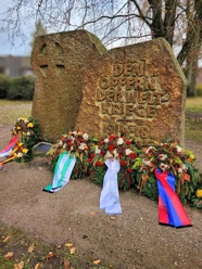 Volkstrauertag .png Gedenkstein für die Opfer der Weltkriege mit Kränzen und Schleifen in Bispingen.