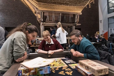 Boardgame Nacht im Museum Schnütgen Drei Menschen spielen Brettspiel im Museum Schnütgen vor historischer Architektur