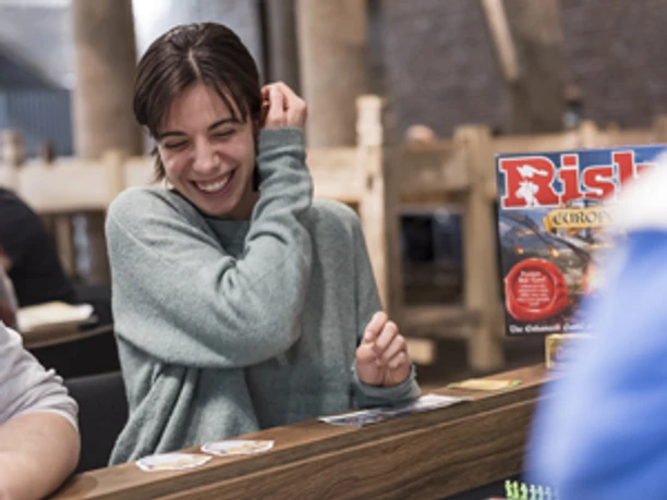 Boardgame Nacht im Museum Schnütgen Lachende Frau spielt Risiko bei der Boardgame-Nacht im Museum Schnütgen