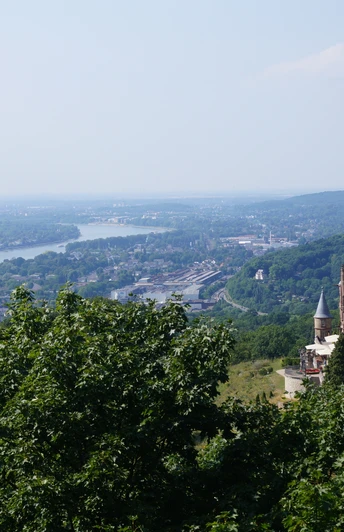 Blick auf Schloss Drachenburg und den Rhein (Richtung Bonn und Köln) Schloss Drachenburg thront majestätisch über dem Rhein, umgeben von üppigen Wäldern und weiter Landschaft.