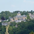Blick auf Schloss Burg in Solingen, umgeben von grünen Wäldern und traditionellen Fachwerkhäusern.