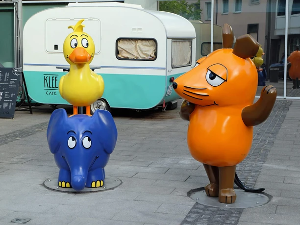 Mouse, Elephant, and Duck in front of the WDR Cologne building Colorful figures of a mouse, an elephant, and a duck in front of the WDR building in Cologne