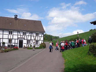 Olpermühle <p>Gruppe von Wanderern vor einem traditionellen Fachwerkhaus in ländlicher Umgebung bei sonnigem Wetter.</p>