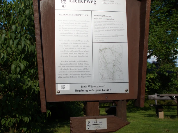 Startpunkt vom Liederweg Hölzernes Schild auf grüner Wiese, informiert über den Liederweg in Traunkirchen, Oberösterreich.