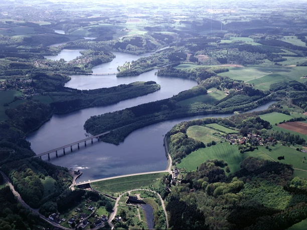 Wuppertalsperre Luftaufnahme eines weiten, grünen Tals mit Seen, Flüssen und Brücken in Oberösterreich.