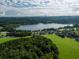 Brucher-Talsperre Marienheider Stausee, von Wald und Wiesen umgeben, bei sonnigem Wetter mit vereinzelten Wolken.