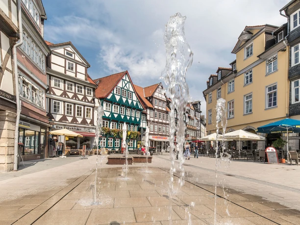 Wasserspiel in den Krambuden Ein Platz umgeben von Fachwerkhäusern, Wasser sprudelt aus Bodendysen