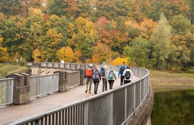 Wandern an der Lingesetalsperre Eine Wandergruppe wandert über die Staumauer der Lingesetalsperre.