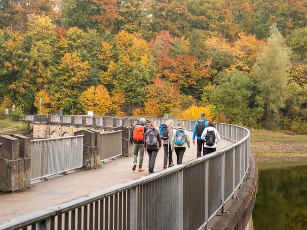 Wandern an der Lingesetalsperre Eine Wandergruppe wandert über die Staumauer der Lingesetalsperre.