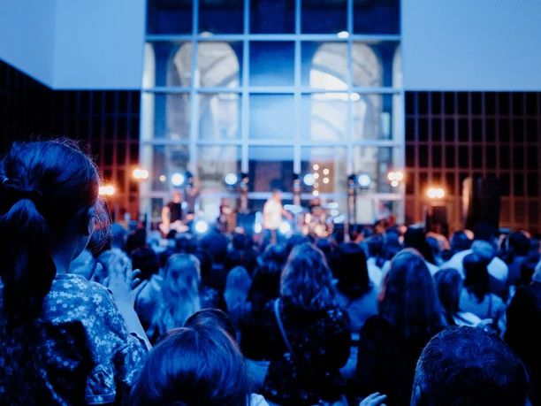 Kölner Museumsnacht 2026 Publikum vor blau beleuchteter Bühne bei Live-Musik der Kölner Museumsnacht