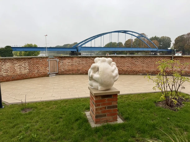 Sculpture "Refuge" at Hoya Castle (1).jpeg White sculpture titled “Refuge” on a brick pedestal at Grafenschloss Hoya, with the Weser Bridge.