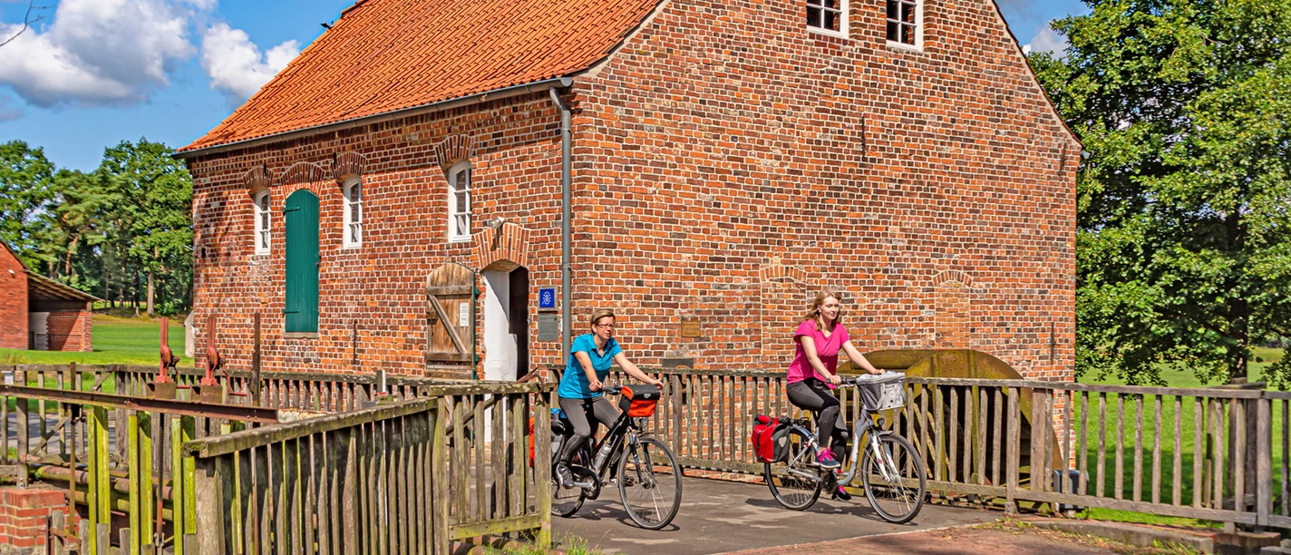 Radfahrerinnen an der Wassermühle Bademühlen