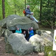 Wanderer beim Großsteingrab Steinfelder Holz mit Qualitätsweg-Logo Wanderer beim Großsteingrab Steinfelder Holz mit Qualitätsweg-Logo