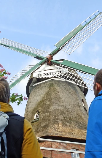 Wanderer schauen auf zu den Flügeln der Windmühle "Henriette" Wanderer schauen auf zu den Flügeln der Windmühle "Henriette"