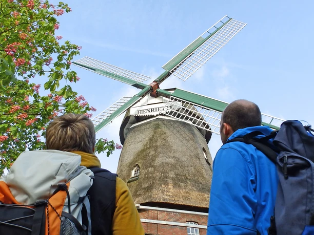 Wanderer schauen auf zu den Flügeln der Windmühle "Henriette" Wanderer schauen auf zu den Flügeln der Windmühle "Henriette"