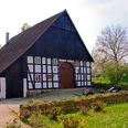 Das Fachwerkhaus auf dem Heimathof Leopoldshöhe steht in gepflegter Gartenlandschaft.