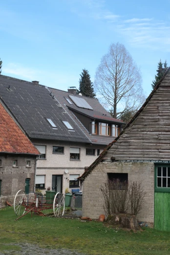Historische Bauernhäuser mit markanten Holzdächern und grünen Türen vor einer malerischen Kulisse.Historic farmhouses with distinctive wooden roofs and green doors set against a picturesque backdrop.Historiske bondehuse med markante trætage og grønne døre i en malerisk kulisse.Historische boerderijen met opvallende houten daken en groene deuren tegen een schilderachtige achtergrond.