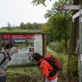 Informationstafel Zwei Wanderer erkunden das Naturlehrgebiet Zwickelbach.