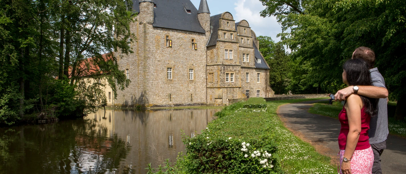 Het kasteel Schelenburg bij Bissendorf wordt weerspiegeld in het water, omgeven door weelderig groen en een romantische sfeer.