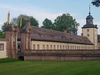 Ehemalige Abtei Corvey mit historischem Bau und Türmen, umgeben von gepflegter Parkanlage.