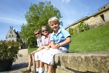 kinder-sitzen-auf-mauer-vor-der-burg-bentheim