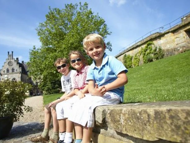kinder-sitzen-auf-mauer-vor-der-burg-bentheim