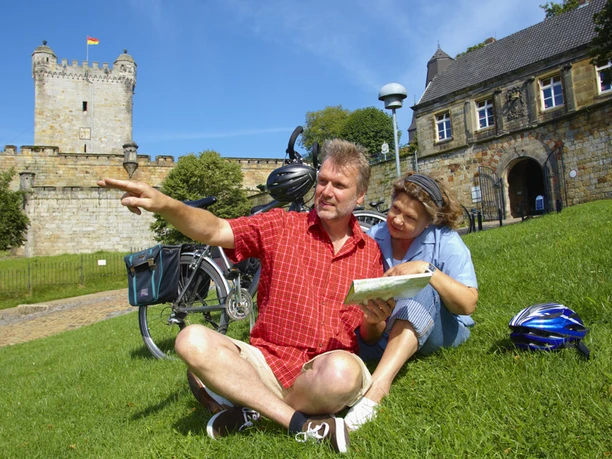 radfahrer-auf-einer-wiese-vor-der-burg-in-bentheim