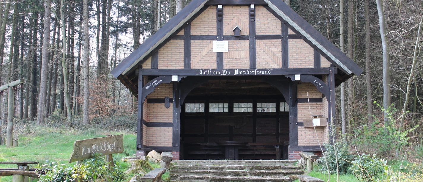 Schutzhütte auf dem Heiligenberg Forest brewery shelter made of wood and bricks, surrounded by tall trees, with wooden access.