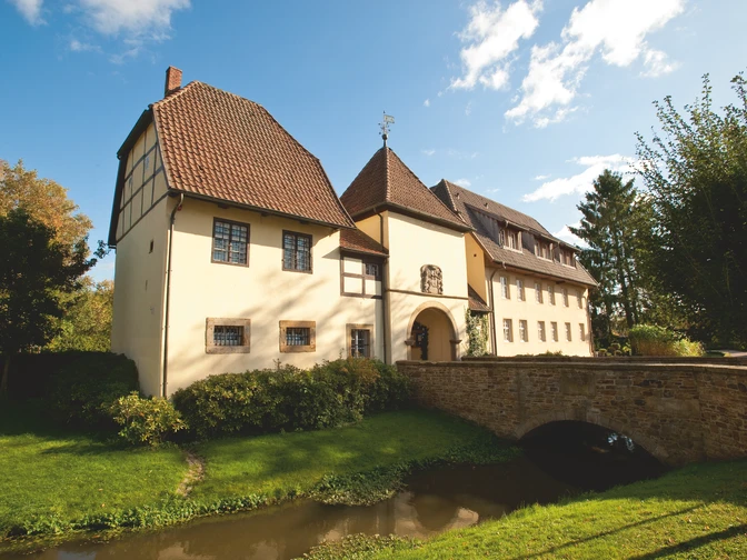 Klosterpforte Bersenbrück Historisches Gebäude mit Fachwerk, umgeben von gepflegtem Garten und einem kleinen Wasserlauf.Historic half-timbered building surrounded by a well-kept garden and a small stream.Historisk bindingsværksbygning omgivet af en velplejet have og et lille vandløb.Historisch vakwerkhuis omringd door een verzorgde tuin en een beekje.