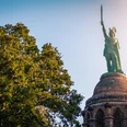 Hermannsdenkmal Das Hermannsdenkmal erhebt sich majestätisch über den Baumwipfeln, mit Hermann, der sein Schwert gen Himmel reckt.