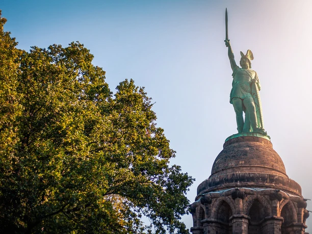 Hermannsdenkmal Das Hermannsdenkmal erhebt sich majestätisch über den Baumwipfeln, mit Hermann, der sein Schwert gen Himmel reckt.