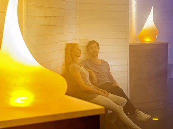 Nebelkammer im Erlebnisgradierwerk Ein Paar entspannt in der nebeligen Atmosphäre des Erlebnisgradierwerks, umgeben von warmem Licht.