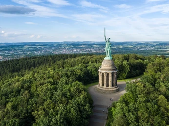 Hermannsdenkmal Luftaufnahme des Hermannsdenkmals inmitten eines ausgedehnten Waldes bei klarem Himmel.