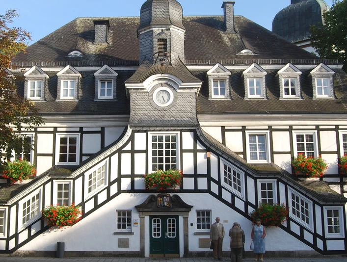Rathaus Rietberg Fachwerk-Rathaus von Rietberg mit symmetrischen Treppenaufgängen, Verzierungen und Blumendekorationen.