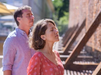 Atemtherapie am Gradierwerk Ein Paar genießt eine wohltuende Atemübung am Gradierwerk, umgeben von rieselndem Wasser.
