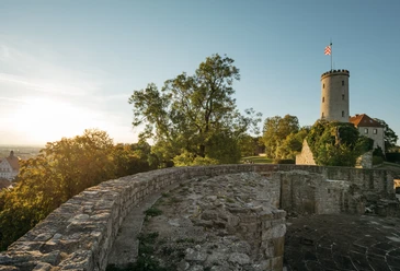 Sparrenburg in Bielefeld Blick auf die Sparrenburg in Bielefeld bei Sonnenuntergang, mit Rundturm und umliegenden Bäumen.