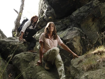 Dörenther Klippen Zwei Personen klettern in felsiger Schlucht der Dörenther Klippen, umgeben von steilen Felsen.