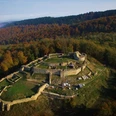Falkenburg Ruine Luftaufnahme der imposanten Ruine Falkenburg, umgeben von buntem Wald, unter klarer Herbstsonne.