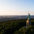 Hermannsdenkmal Hermannsdenkmal in einem bewaldeten Hügelplateau mit Blick auf die weitläufige Landschaft im Hintergrund.