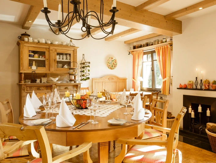 Esstisch im Hotel Ein elegant gedeckter Esstisch in einem hell erleuchteten Hotelraum mit Holzmöbeln und Kerzenleuchter.